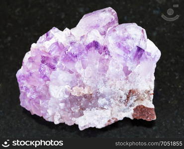 macro shooting of natural mineral rock specimen - raw Amethyst crystal druse on dark granite background from Tersky Coast , Kola Peninsula, Russia