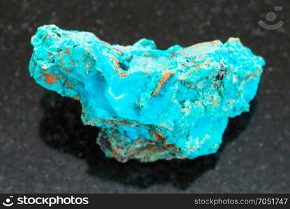 macro shooting of natural mineral rock specimen - raw Chrysocolla stone in copper sandstone on dark granite background from Zabaykalsky Krai of Russia