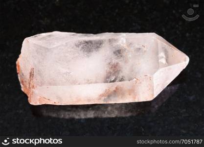 macro shooting of natural mineral rock specimen - raw crystal of rose quartz gemstone on dark granite background from Aldan, Yakutia, Russia
