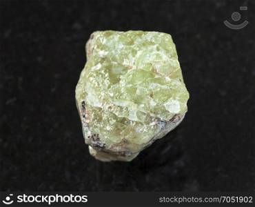 macro shooting of natural mineral rock specimen - raw crystal of Saamite (fluorapatite) gemstone on dark granite background from Lovozero Massif, Kola peninsula, Russia