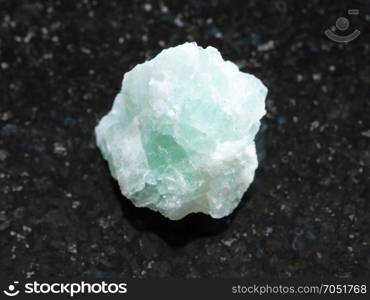 macro shooting of natural mineral rock specimen - raw Fluorite stone on dark granite background