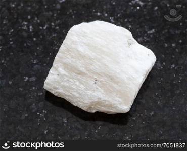 macro shooting of natural mineral rock specimen - raw Gypsum stone on dark granite background