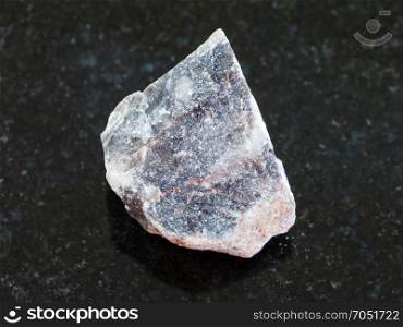 macro shooting of natural mineral rock specimen - raw Limestone stone on dark granite background