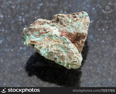 macro shooting of natural mineral rock specimen - raw Malachite (copper ore) stone on dark granite background