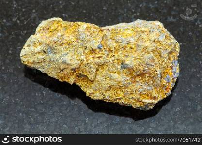 macro shooting of natural mineral rock specimen - raw pyrite ore on dark granite background