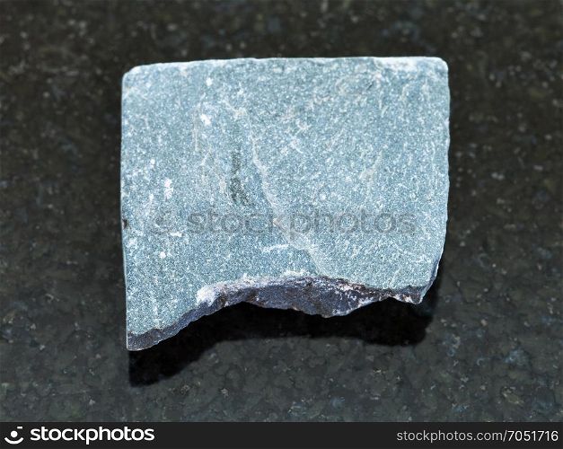 macro shooting of natural mineral rock specimen - raw Slate stone on dark granite background