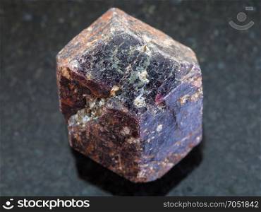 macro shooting of natural mineral rock specimen - rough crystal of dravite tourmaline gemstone on dark granite background from China