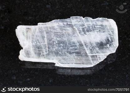 macro shooting of natural mineral rock specimen - rough crystal of Gypsum gemstone on dark granite background