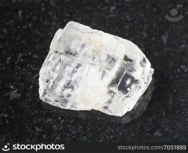 macro shooting of natural mineral rock specimen - rough crystal of Petalite gemstone on dark granite background from Araguaia mine, Brazil