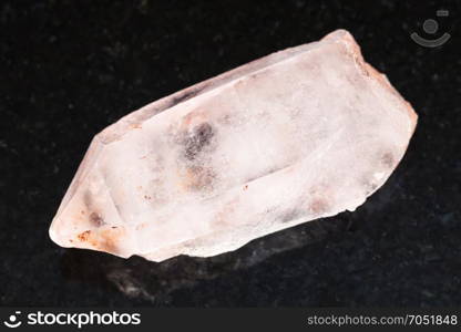 macro shooting of natural mineral rock specimen - rough crystal of rose quartz gemstone on dark granite background from Aldan, Yakutia, Russia