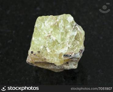 macro shooting of natural mineral rock specimen - rough crystal of Saamite (fluorapatite) gemstone on dark granite background from Lovozero Massif, Kola peninsula, Russia