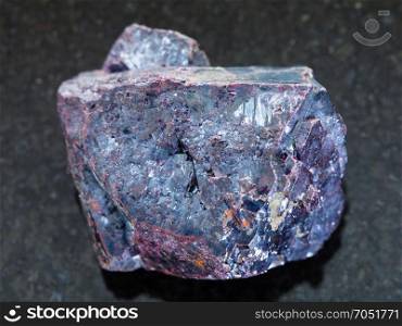 macro shooting of natural mineral rock specimen - rough Cuprite stone on dark granite background from Altai Mountains, Russia