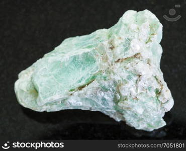 macro shooting of natural mineral rock specimen - rough green talc stone on dark granite background from Shabrovsky (Shabry) district of Sverdlovk region, Ural Mountains, Russia