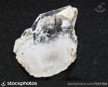 macro shooting of natural mineral rock specimen - rough rock-crystal of quartz gemstone on dark granite background