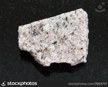 macro shooting of natural mineral rock specimen - rough Schist stone on dark granite background