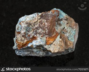 macro shooting of natural mineral rock specimen - rough Scorodite stone on dark granite background from Jezkazgan region, Kazakhstan