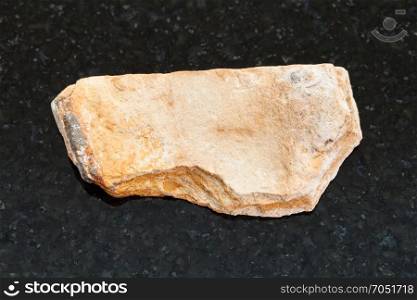 macro shooting of natural mineral rock specimen - rough Shale stone on dark granite background