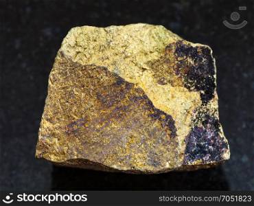 macro shooting of natural mineral rock specimen - rough yellow Chalcopyrite stone on dark granite background from Safyanovskoe mine, Sverdlovsk region, Ural Mountains, Russia