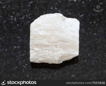 macro shooting of natural mineral rock specimen - white Gypsum stone on dark granite background