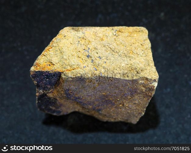 macro shooting of natural mineral rock specimen - yellow Chalcopyrite stone on dark granite background from Safyanovskoe mine, Sverdlovsk region, Ural Mountains, Russia