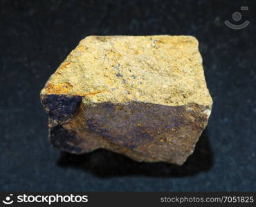 macro shooting of natural mineral rock specimen - yellow Chalcopyrite stone on dark granite background from Safyanovskoe mine, Sverdlovsk region, Ural Mountains, Russia