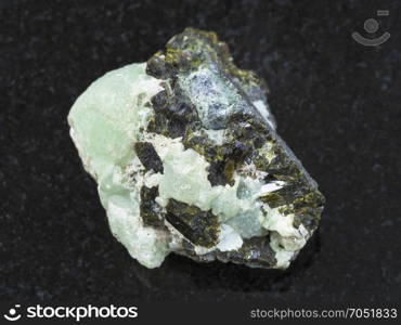 macro shooting of natural mineral stone specimen - Epidote crystals on prehnite gemstone on dark granite background