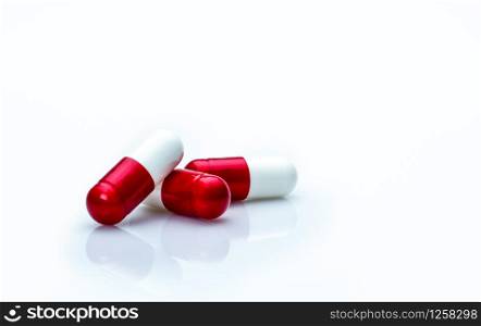Macro shot detail of red, white antibiotics capsule pills isolated on white background with copy space. Antibiotic drug use with reasonable concept. Antimicrobial drug resistance concept.