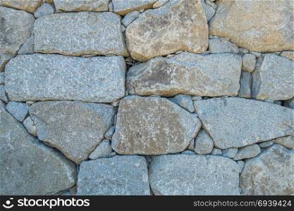 Macro shot of a wall made up of huge boulders.