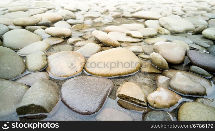 Macro shot of big pebbles lying in river