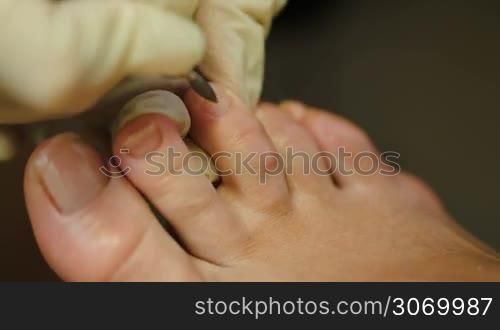 Macro shot of female feet under pedicure at beauty spa salon