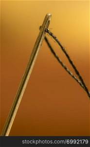 macro shot of needle with eye black thread. Close up
