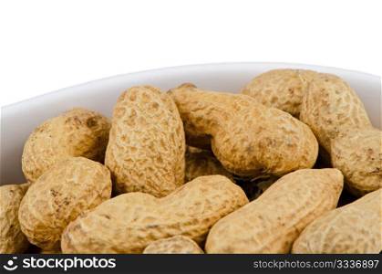 Macro shot of peanuts in a ceramic container on white background.