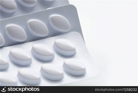 Macro shot of pills in white blister pack for light resistance packaging isolated on white background. Medicine for treatment dyslipidemia. Lipid lowering tablets pills. Statins : Hyperlipidemia.