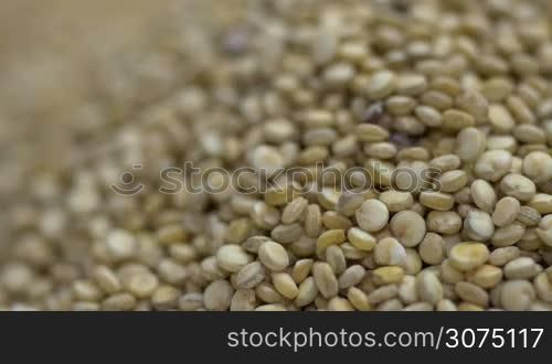 Macro shot of Quinoa seeds falling into a pile of quinoa