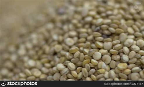 Macro shot of Quinoa seeds falling into a pile of quinoa
