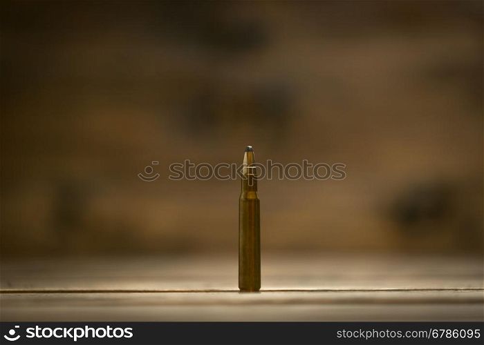 Macro shot of riffle bullet against dark wooden background