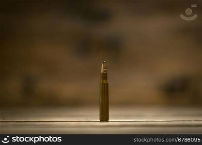 Macro shot of riffle bullet against dark wooden background