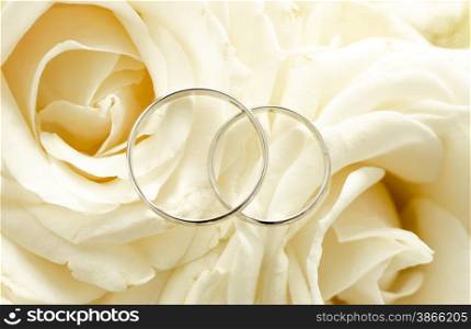 Macro shot of two wedding rings lying on bridal bouquet