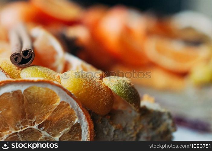 Macro view of delicious vegan citrus dessert decorated with fresh oranges and dry spices, cinnamon sticks, blurred backdrop. Selective focus. Colorful, healthy and juicy. Image for cafe menu or confectionery catalog