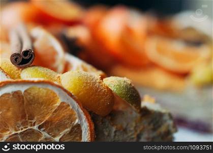 Macro view of delicious vegan citrus dessert decorated with fresh oranges and dry spices, cinnamon sticks, blurred backdrop. Selective focus. Colorful, healthy and juicy. Image for cafe menu or confectionery catalog