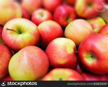 Macro view of the heap of fresh red apples at the food market, supermarket or grocery store with selective focus effect