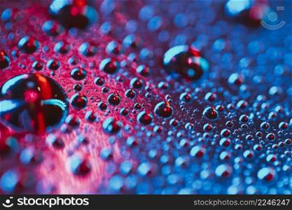 macro water droplets surface pink blue backdrop