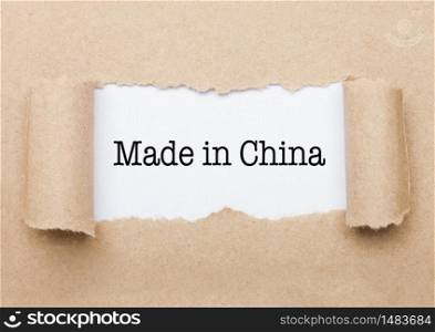 Made in China concept text appearing behind torn brown paper envelope