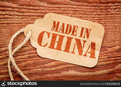 made in China sign - red stencil text on a paper price tag against grunge wood