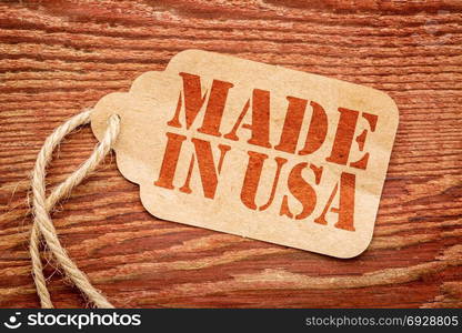 made in USA sign - red stencil text on a paper price tag against grunge wood