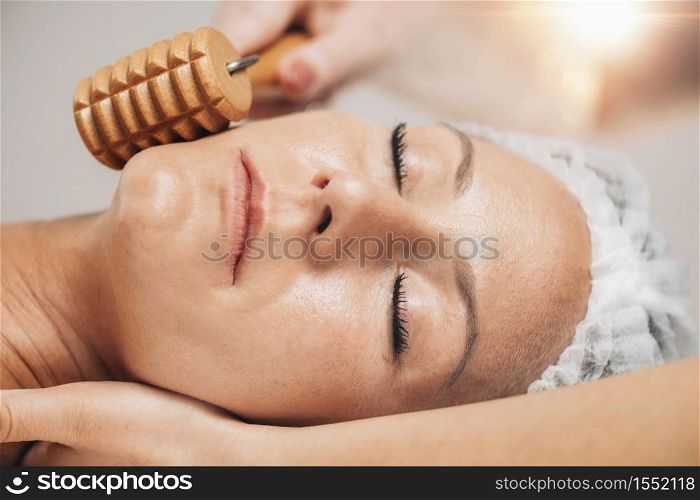 Maderotherapy Face Massage with Wooden Roller. Reducing Wrinkles and Sagging Cheeks