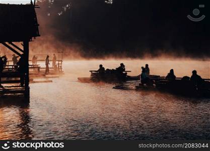 Mae Hong Sorn, Thailand - December 17, 2021 : Beautiful lake over the misty river at sunrise with traveler on the Bamboo raft. Morning view at Pang Oung Lake (Pang Tong reservoir), Mae hong son, Thail