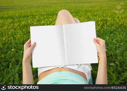 Magazine of in a lap reading person against a field. Rest with reading