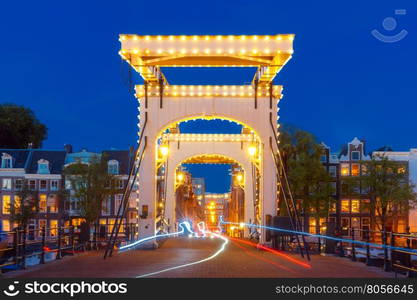 Magere Brug, Skinny bridge, with night lighting over the river Amstel in the city centre of Amsterdam, Holland, Netherlands