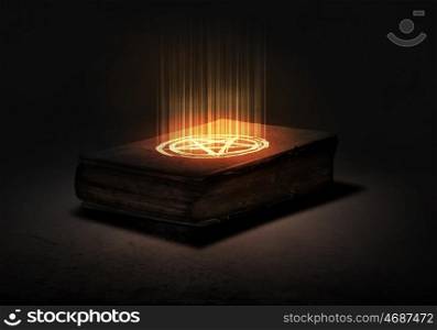 Magic book. Old black magic book with lights on pages